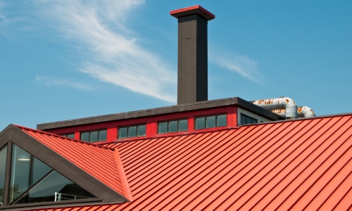 A commercial building with a tall chimney.
