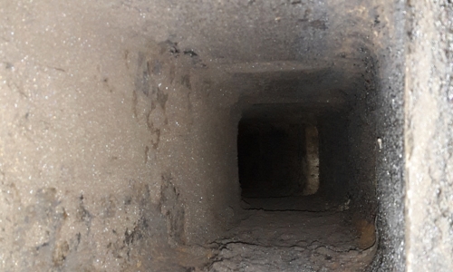 A dirty commercial chimney stack inside with a build of soot.
